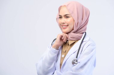 Beyaz arka plan stüdyosu üzerinde tesettüre sahip bir kadın Müslüman doktor..
