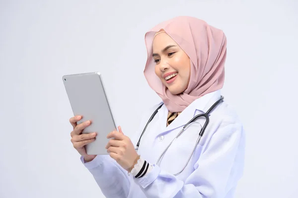 stock image A female muslim doctor with hijab over white background studio.