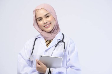 Beyaz arka plan stüdyosu üzerinde tesettüre sahip bir kadın Müslüman doktor..