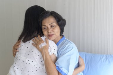 Hastanedeki kıdemli hasta kadın ve destekleyici kızı, sağlık ve sigorta konsepti.