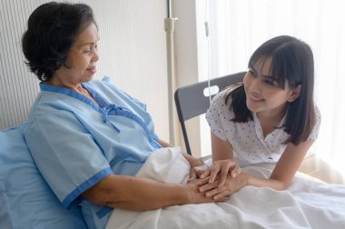 Hastanedeki kıdemli hasta kadın ve destekleyici kızı, sağlık ve sigorta konsepti.