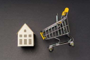 Siyah arka plan stüdyosunun üzerinde küçük beyaz bir ev.