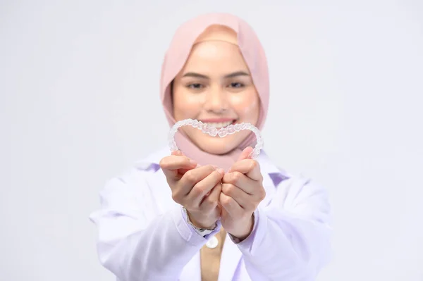 Uma Dentista Muçulmana Segurando Aparelhos Invisalign Sobre Estúdio Fundo Branco — Fotografia de Stock