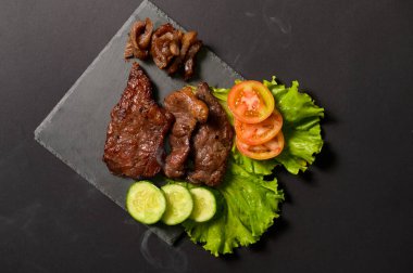 Siyah arka plan stüdyosunun üstünde ızgara biftek.