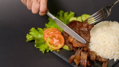 Siyah arka plan stüdyosunun üstünde pirinçli ızgara biftek.