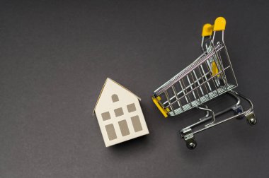 Siyah arka plan stüdyosunun üzerinde küçük beyaz bir ev.