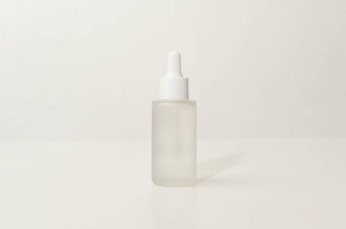 Beyaz arka plan stüdyosunun üzerinde nemlendirici krem şişesi, paketleme ve cilt güzellik konsepti