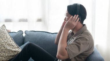 Asyalı bir adam dinliyor Oturma odasında müzik . 