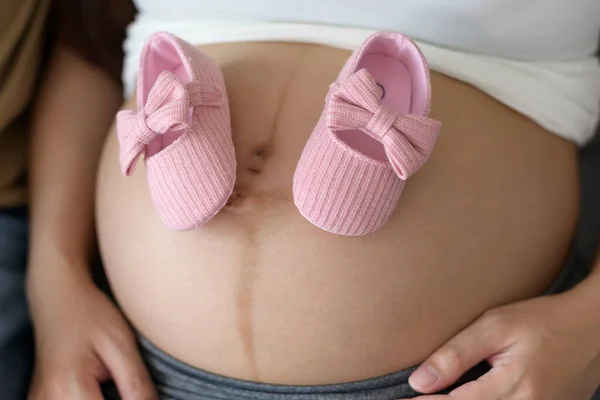 Mujer Embarazada Joven Que Pone Zapatos Bebé Vientre Familia Concepto — Foto de Stock