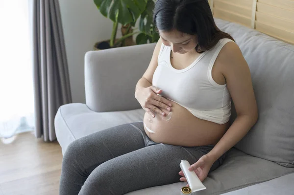 Młoda Kobieta Ciąży Nakłada Krem Nawilżający Brzuch Opiekę Zdrowotną Ciążę — Zdjęcie stockowe