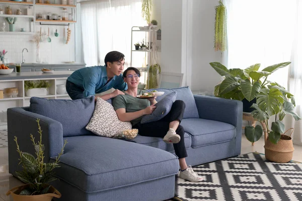 Genç, gülümseyen eşcinsel çift evde sağlıklı yemek yiyor, LGBTQ ve çeşitlilik konsepti.