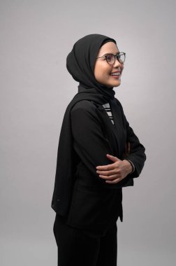 Beyaz arka plan stüdyosuna gözlük takan güzel bir Müslüman kadın.