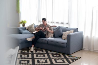 Bir müzisyen stüdyoda şarkı yazıyor. 