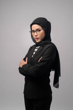 Beyaz arka plan stüdyosuna gözlük takan güzel bir Müslüman kadın.