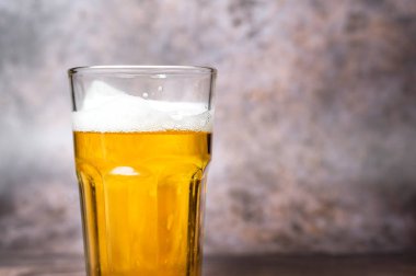 Soğuk hava hafif birası şişeden dökülüyor ahşap masa üzerine 