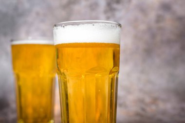 Soğuk hava hafif birası şişeden dökülüyor ahşap masa üzerine 