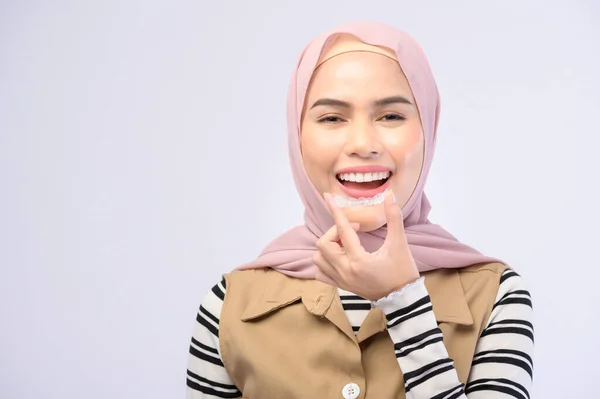 スタジオ 歯科医療 歯列矯正の概念でInvisalineブレースを保持している若いイスラム教徒の女性 — ストック写真
