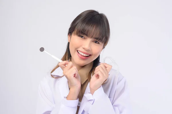 白い背景のスタジオで笑顔の若い女性歯科医 — ストック写真