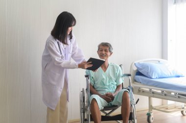 Doktor, yaşlı bir hastaya hastane, sağlık ve tıbbi konseptte tekerlekli sandalyeye taşınması için yardım ediyor.