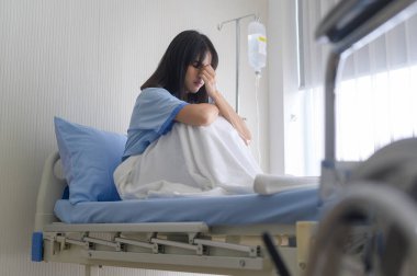 Çaresiz bir Asyalı kadın hasta. Doktorun, kanserin seyrinin sonuna yaklaştığı yönündeki açıklamasının ardından,.