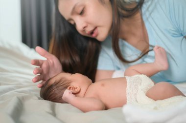 Yeni doğmuş şirin bir bebeği olan genç bir anne..