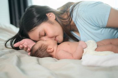 Yeni doğmuş şirin bir bebeği olan genç bir anne..