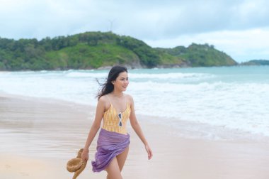 Bikini 'de genç ve güzel bir kadın sahilde eğleniyor ve dinleniyor. Yaz, tatil, tatil, yaşam tarzı konsepti..