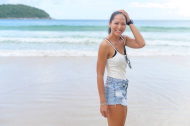 Genç ve güzel bir kadın sahilde keyif alıyor ve dinleniyor. Yaz, tatil, tatiller, yaşam tarzları konsepti..