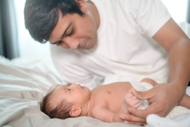 Yeni doğmuş şirin bir bebeği olan genç bir baba..