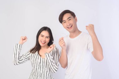 Genç gülümseyen bir adam ve elinde diş telleri olan bir kadın beyaz arka plan stüdyosu, diş sağlığı ve ortodontik konsept üzerinde....