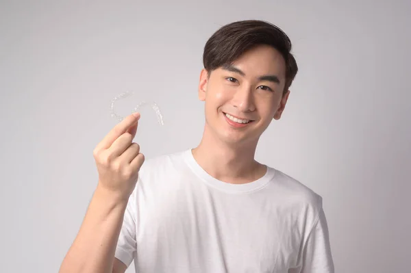Young Smiling Man Holding Invisalign Braces White Background Studio Dental — Stok fotoğraf