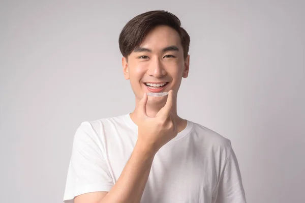 Young Smiling Man Holding Invisalign Braces White Background Studio Dental — Zdjęcie stockowe