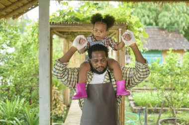 Mutlu melez ırk babası ve küçük kız tarım uzmanı tarım arazisinde eğleniyor ve çalışıyor.