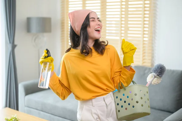 Młoda Szczęśliwa Kobieta Żółtych Rękawiczkach Trzymająca Koszyk Środków Czystości Salonie — Zdjęcie stockowe