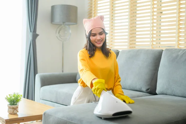 Young Happy Woman Wearing Yellow Gloves Vacuum Cleaning Sofa Living — Zdjęcie stockowe