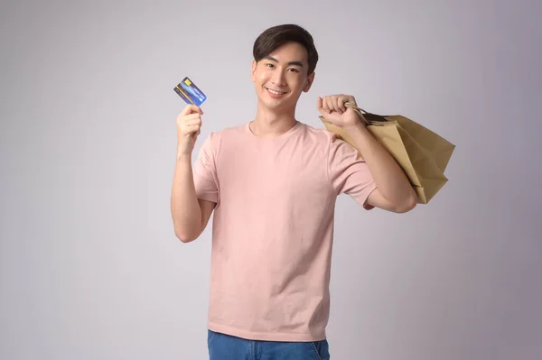 Young Asian Man Holding Credit Card Shopping Bag White Background — Zdjęcie stockowe