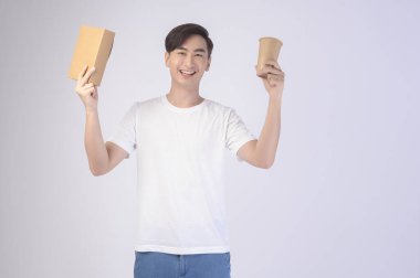 Beyaz arka plan üzerinde kağıt bardak ve kağıt kutu tutan Asyalı genç bir adam, Dünya 'yı Kurtar kavramını