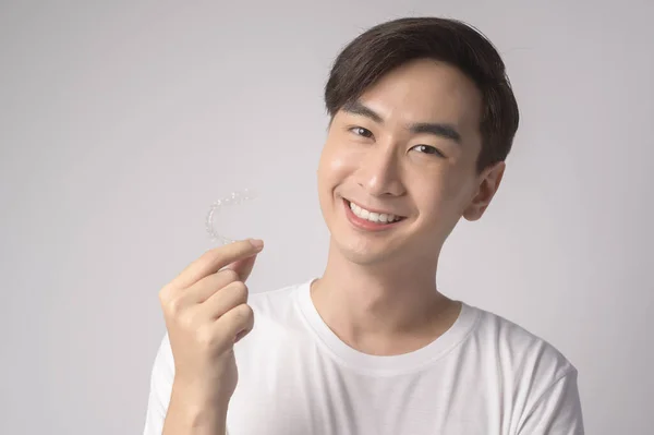 Young Smiling Man Holding Invisalign Braces White Background Studio Dental — Stok fotoğraf