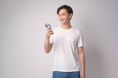A Young asian man using smartphone over white background, technology concept. 		