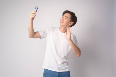 A Young asian man using smartphone over white background, technology concept. 		