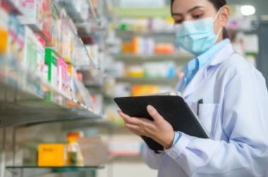 Modern bir eczanede yüz maskesi takan kadın eczacının portresi..