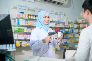 A Female muslim pharmacist counseling customer about drugs usage in a modern pharmacy drugstore.