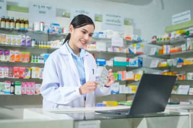 A Female pharmacist counseling customer via video call in a modern pharmacy drugstore.