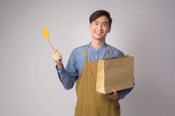 Portrait Young Asian Man Wearing Apron Holding Paper Bag Turner — Foto de Stock