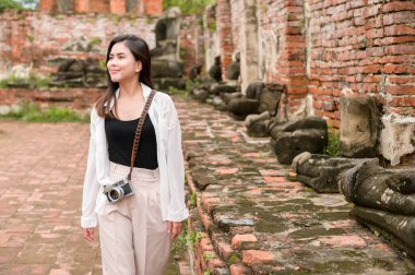 young beautiful woman traveling and taking photo at thai historical Park, Holidays and cultural tourism concept.