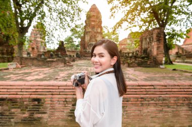 young beautiful woman traveling and taking photo at thai historical Park, Holidays and cultural tourism concept.