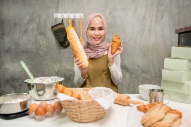 A Young beautiful muslim woman is baking in her kitchen , bakery and coffee shop business