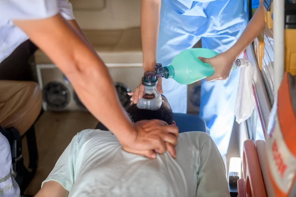 Group of rescue emergency team transporting patient from Emergency car  through Hospital Corridors. cardio pulmonary resuscitation on an unconscious patient .