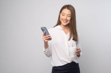 A Young asian woman using smartphone over white background, technology concept. 		
