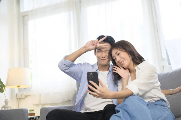 Una Joven Sonriente Pareja Asiática Sosteniendo Teléfono Inteligente Haciendo Videollamada — Foto de Stock